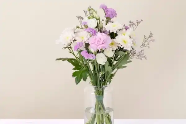 Un bouquet de fleurs coupées dans les tons rose et blanc de fleurs variées.