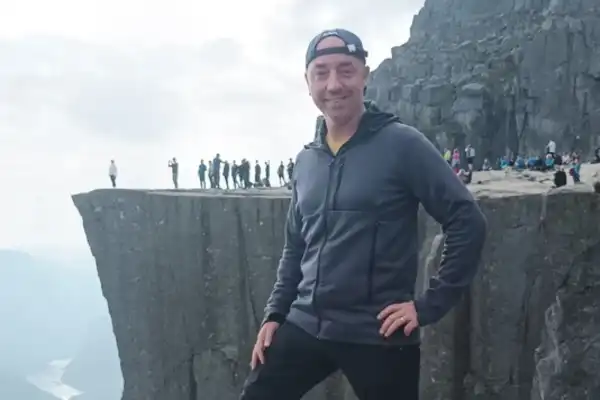 Portrait du responsable opérationnel du Domaine d'Angély en Norvège devant un fjord, symbolisant l'esprit d'aventure et la polyvalence de l'équipe de Saint-Jean-d'Angély.