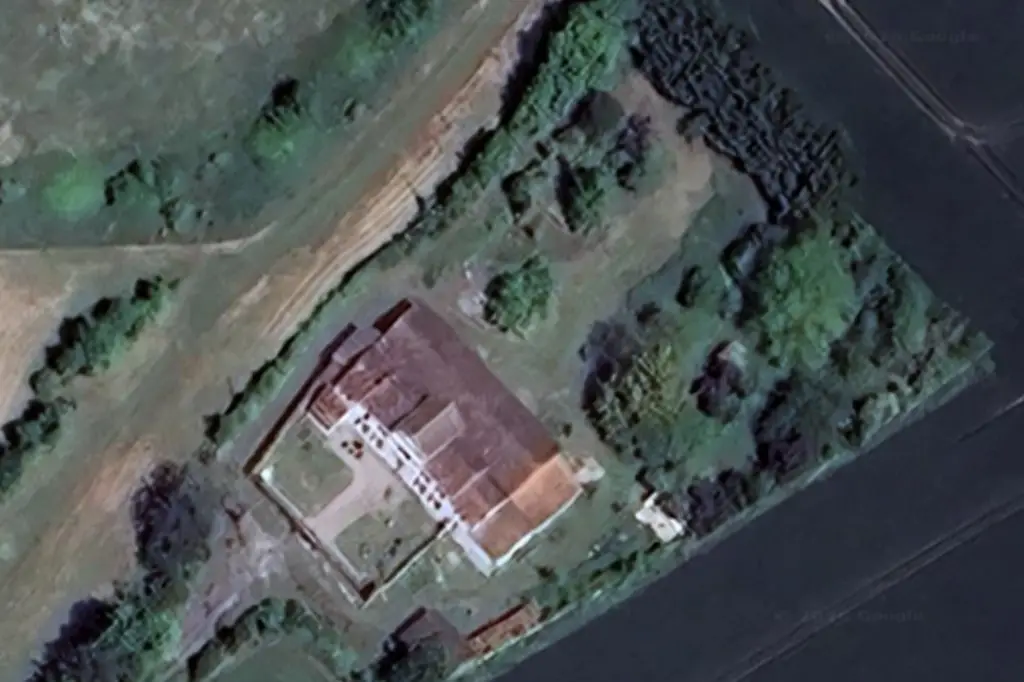 Photographie aérienne du Domaine d'Angély montrant la maison de maître rose au centre d'un vaste parc arboré, entourée de champs et de bosquets sous un ciel bleu.